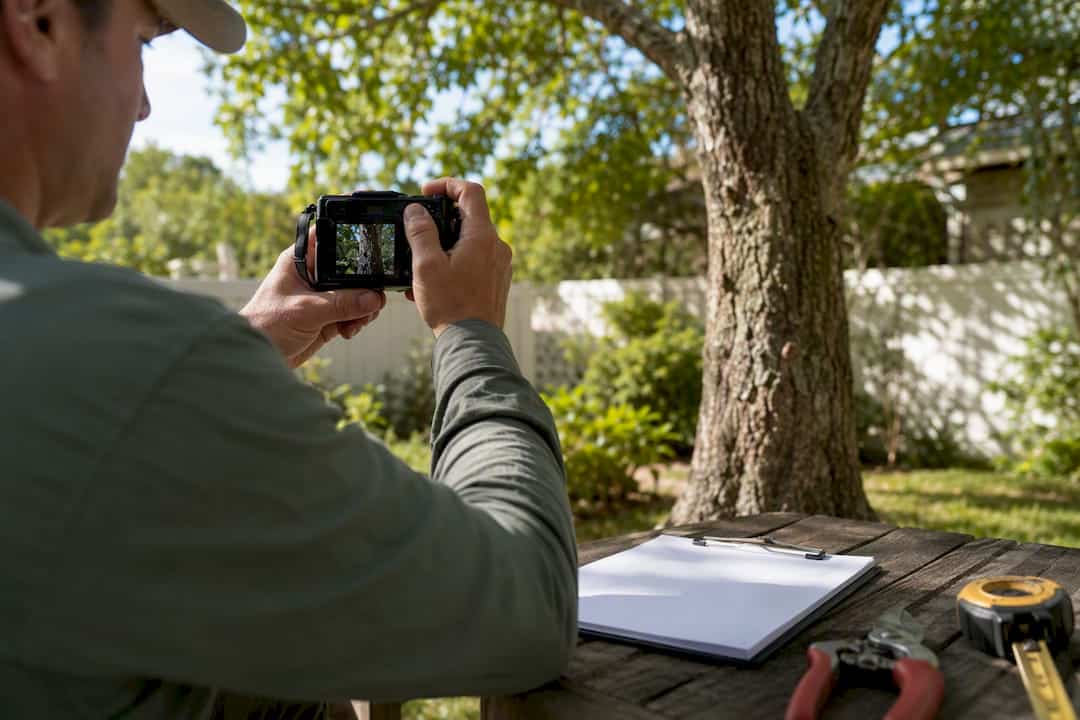 Who Controls Tree Removal Under HOA Rules in Florida? 1 Arborist documenting tree with camera and tools